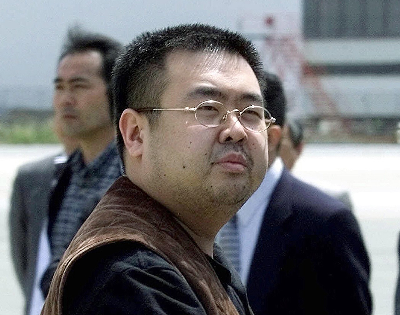 In this 2001 photo, a man believed to be Kim Jong Nam, the eldest son of then North Korean leader Kim Jong Il, looks at a battery of photographers as he exits a police van to board a plane to Beijing at Narita international airport in Narita, northeast of Tokyo. (AP Photo/Shizuo Kambayashi, File)