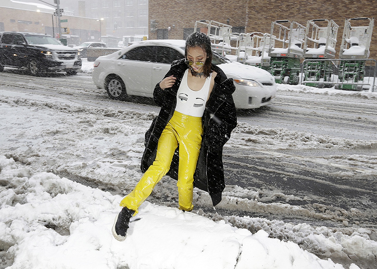 A woman tries to step over a snow mound as she arrives to a show during Fashion Week in New York on Thursday, Feb. 9. (AP Photo/Seth Wenig)