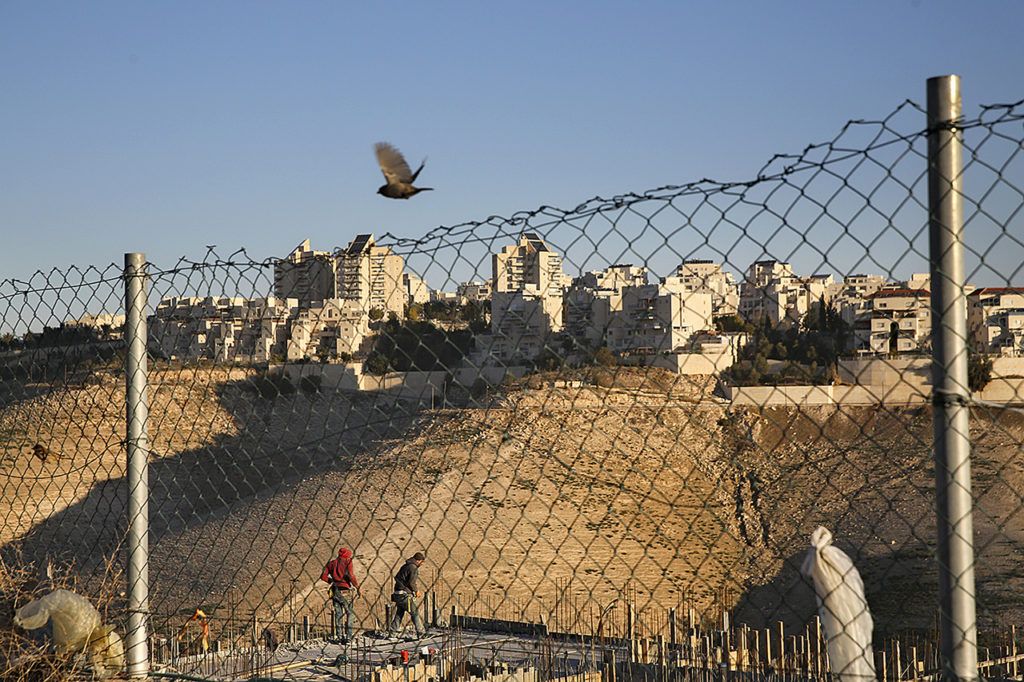 Palestinian laborers work at a construction site in a new housing project in the Israeli settlement of Maale Adumim, near Jerusalem, on Tuesday, Feb. 7. (AP Photo/Oded Balilty)

