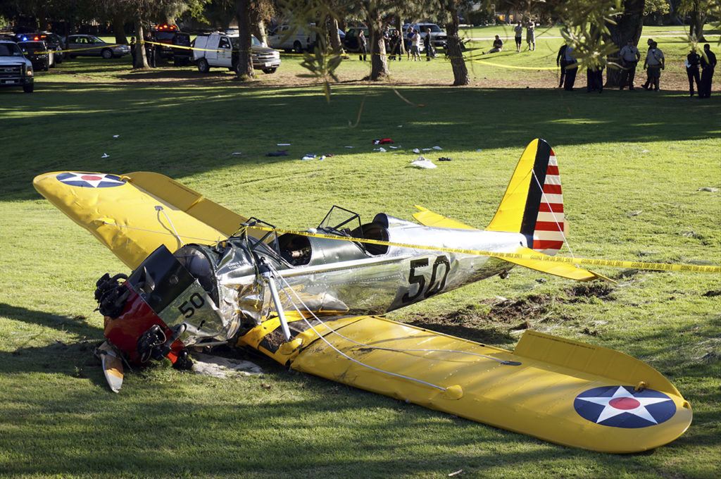 In this 2015 photo, a World War II-era trainer airplane rests on the ground after actor Harrison Ford crash-landed it after reporting engine failure on the Penmar Golf Course in the Venice area of Los Angeles. (AP Photo/Damian Dovarganes, File)
