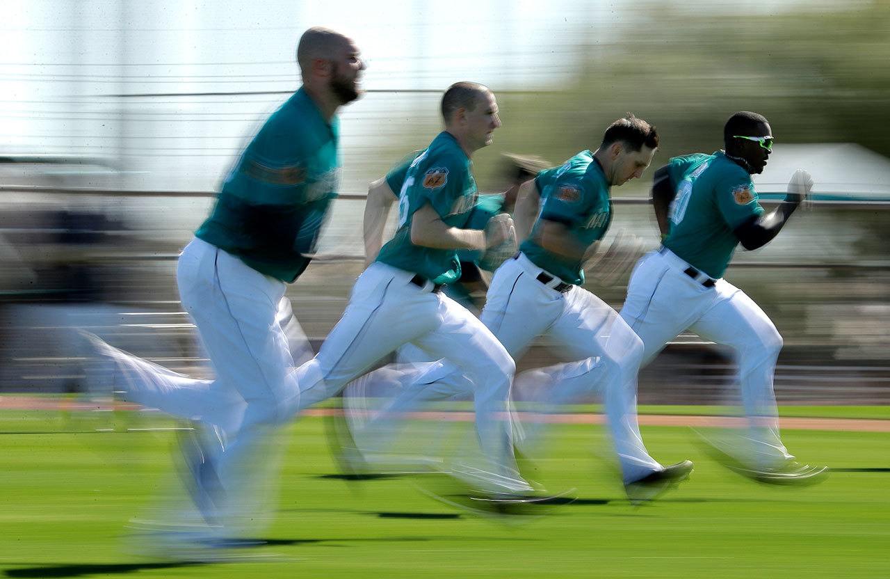 Mariners players run sprints during spring training on Feb. 15, 2017, in Peoria, Ariz. (AP Photo/Charlie Riedel)