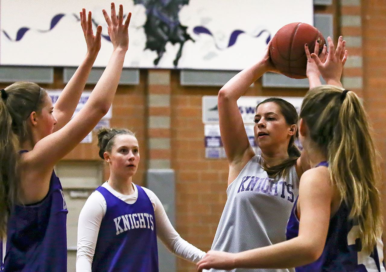 Kamiak’s Sarah Payne (second from right) looks to pass with teammates Hunter Beirne (left), Alex Gallaher (second from left) and Karsen Alexander defending during practice on Feb. 23, 2017, at Kamiak High School in Mukilteo. (Kevin Clark / The Herald)