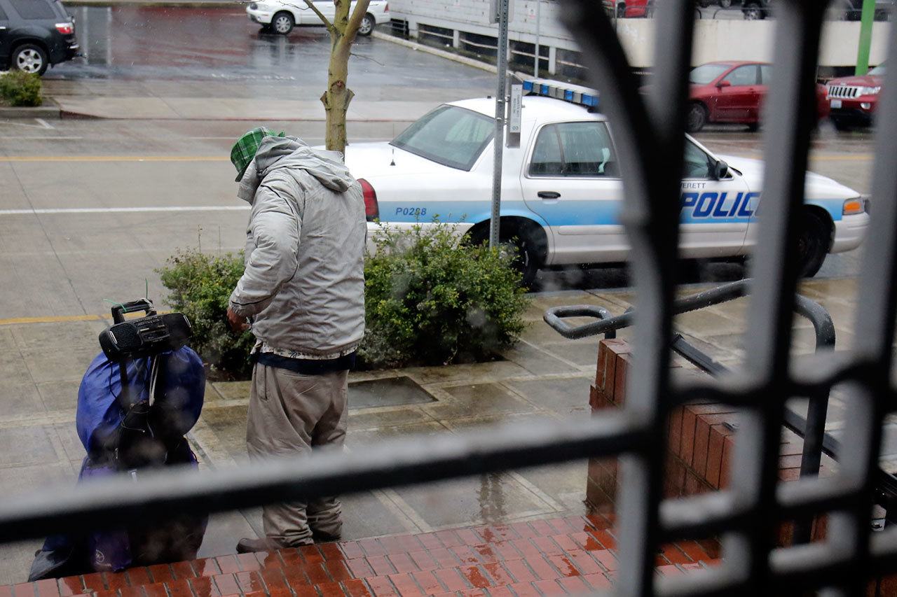 A patron collects himself after being asked to leave for sleeping in the Everett Public Library on Wednesday afternoon. (Kevin Clark / The Herald)