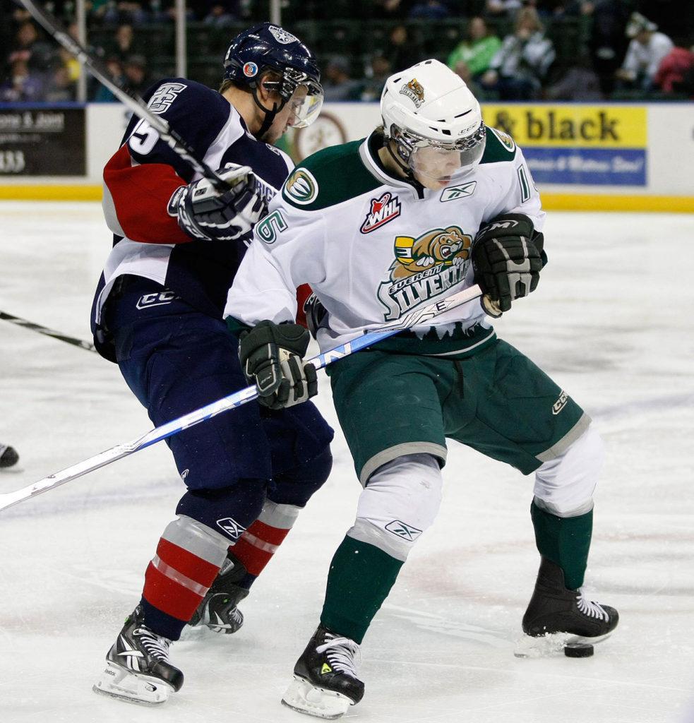 Former Silvertip Kellan Tochkin (right) controls the puck with his skate during a game against Tri-City in 2011. Tochkin returned to Everett this past Saturday to take part in Silvertips Alumni Night. (Jennifer Buchanan / The Herald)
