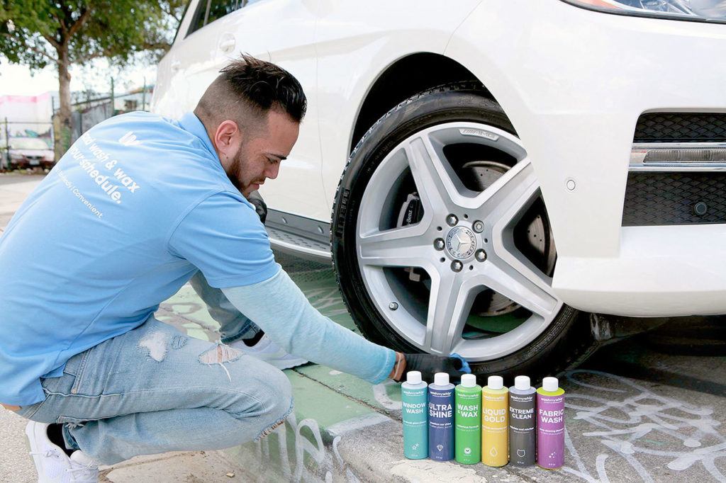 Fidel Miranda, hiring manager of WashMyWhip, works on a car using the company’s waterless products. (Roberto Koltun /Miami Herald)

