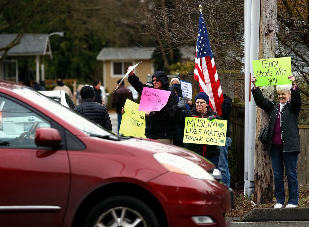 Neighbors of the Evergreen Islamic Insititue — many of them from area churches — express support and love to Muslims arriving at the Lynnwood mosque. (Dan Bates / The Herald)
