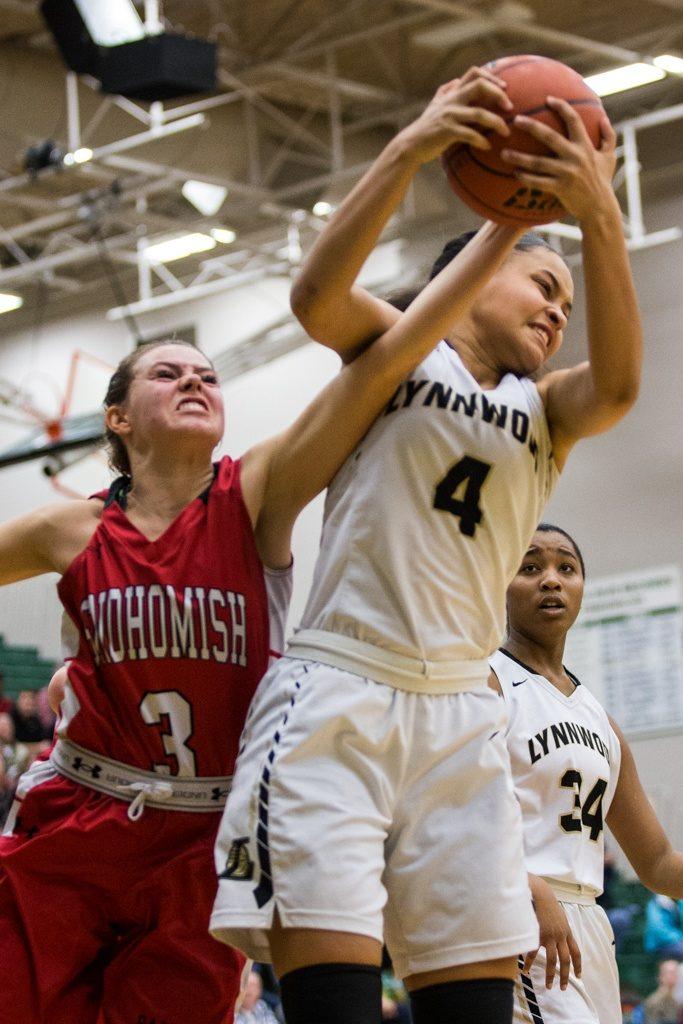 Lynnwood’s Nakia Boston grabs a rebound over Snohomish’s Katie Brandvold during the championship game of the 3A District 1 girls basketball tournament Feb. 17, 2017, at Jackson High School in Mill Creek. Lynnwood beat Snohomish 55-53. (Daniella Beccaria / The Herald)
