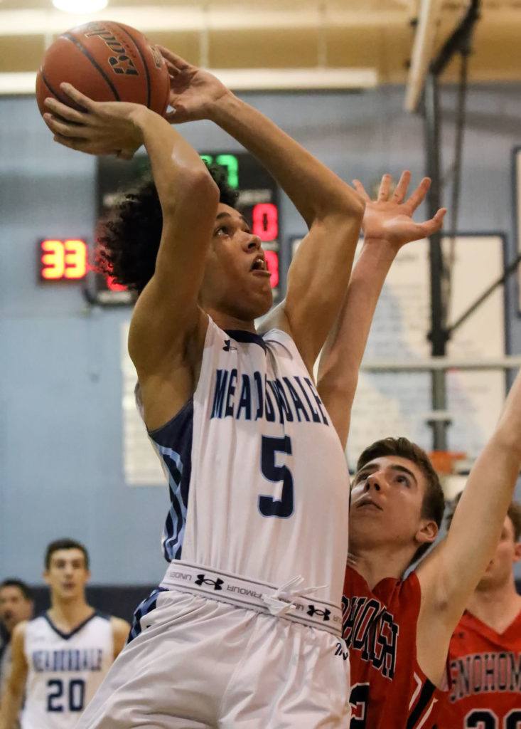 Meadowdale’s Xavier Meekins attempts a shot over Snohomish’s Kolton Smith during a 3A district play-in game on Feb. 10, 2017, at Meadowdale High School in Lynnwood. The Mavericks won 66-54. (Kevin Clark / The Herald)
