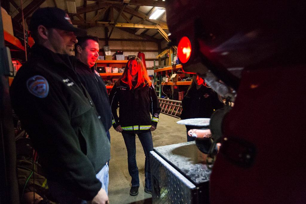 Oso fire Capt. Tim Harper, chaplain and firefighter Joel Johnson and firefighter Cyndy Olson inspect a newly repaired firetruck at the station on Highway 530 in Oso on Tuesday. (Daniella Beccaria / The Herald)
