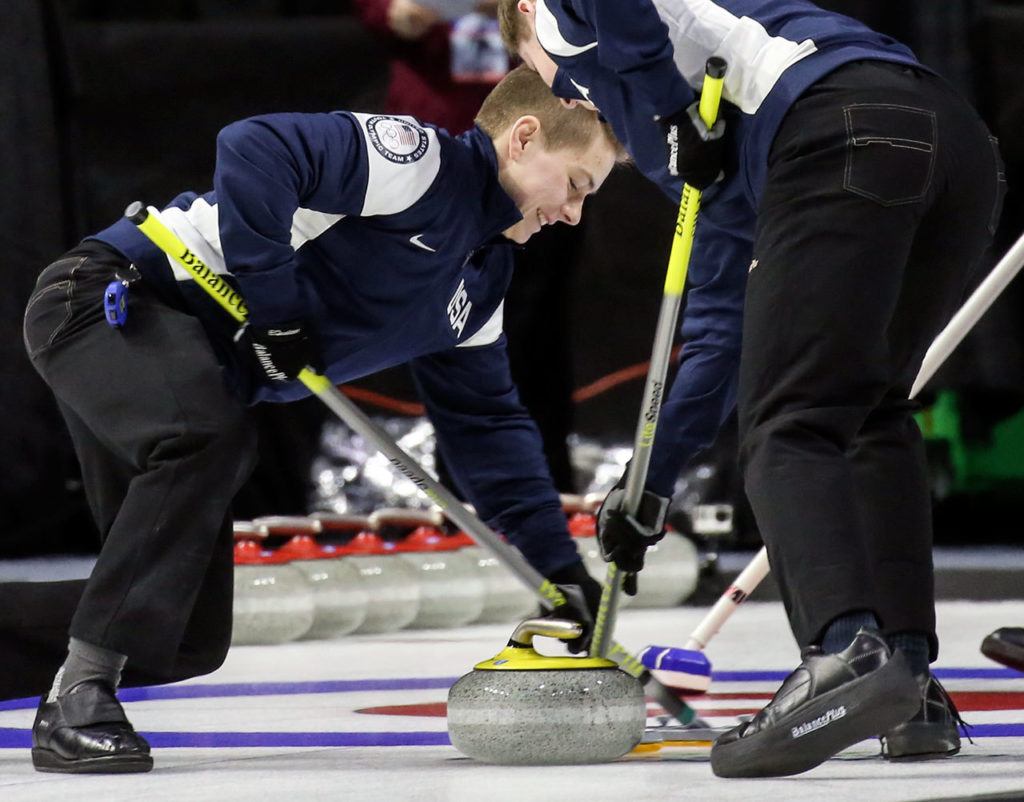 Lake Stevens’ Luke Violette (left) and Issaquah’s Ben Richardson sweep the ceremonial opening stone during the opening ceremony of the 2017 USA Curling Nationals on Feb. 11, 2017, at Xfinity Arena in Everett. (Kevin Clark / The Herald)
