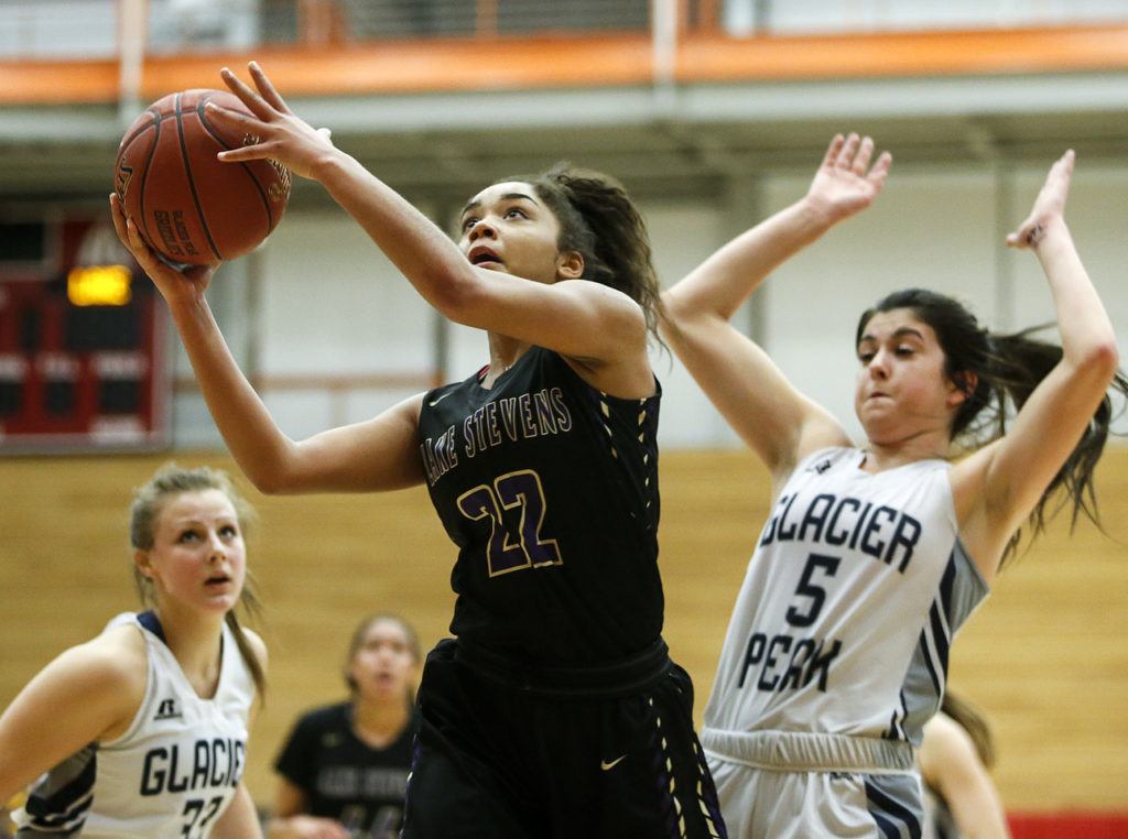 Lake Stevens’ Raigan Reed (22) goes to the hoop as she’s pursued by Glacier Peak’s Samantha Fatkin (5) during the Class 4A District 1 girls basketball championship game at Everett Community College on Thursday, Feb. 16. Glacier Peak went on to defeat Lake Stevens 60-41. (Ian Terry / The Herald)
