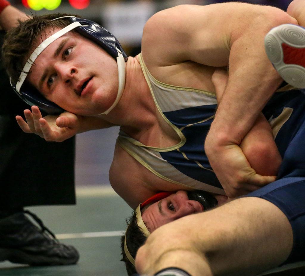 Arlington’s Colton Ferro works to pin Kamiakin’s Luke Eskelsen in a 195-pound match at the 3A Region 3 Tournament on Feb. 11 at Everett High School. Ferro won 9-6. (Kevin Clark / The Herald)
