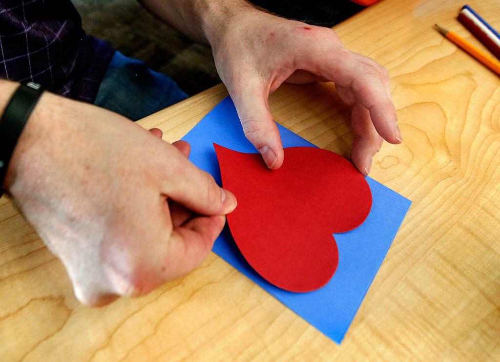 With instruction from fourth-grader Kasen Cooley, Benjamin Studley glues the heart onto a Valentine’s Day card Thursday at Machias Elementary School. (Dan Bates / The Herald)

