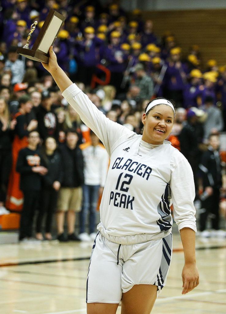 Glacier Peak’s Kayla Watkins hoists the Class 4A District 1 girls basketball championship game trophy after defeating Lake Stevens at Everett Community College on Thursday, Feb. 16. (Ian Terry / The Herald)
