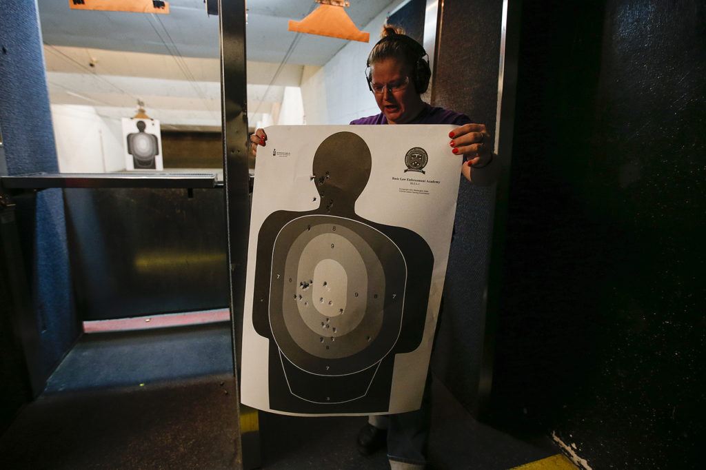 Marlene Wing, of Marysville, looks over her target following a shooting session with other members of the Snohomish County chapter of The Well Armed Woman at the Norpoint Shooting Center in Arlington on Saturday, Feb. 4. (Ian Terry / The Herald)
