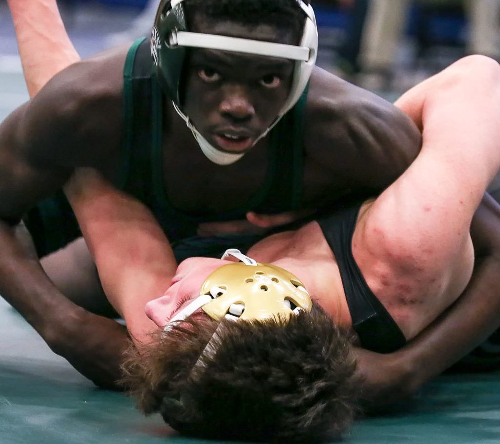 Edmonds-Woodway’s Salihou Fatty looks to the clock in the midst of a 132-pound match with Oak Harbor’s Blake McBride at the 3A Region 3 Tournament on Feb. 11 at Everett High School. Fatty won 10-5. (Kevin Clark / The Herald)
