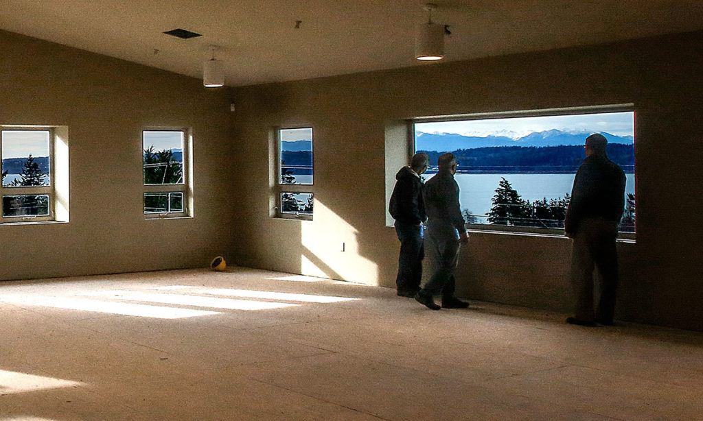 Ray Harrison (left), Mark Peterson and Jon Rice pause to take in the view from the Fellowship Room upstairs in Camano Chapel’s new Saratoga Hall. Harrison is a member of the administrative board and his role is overseeing facilities. Peterson is the facilities director as well as project manager. Jon Rice is the church administrator. The Fellowship Room is fire-approved for 450 people. (Dan Bates / The Herald)
