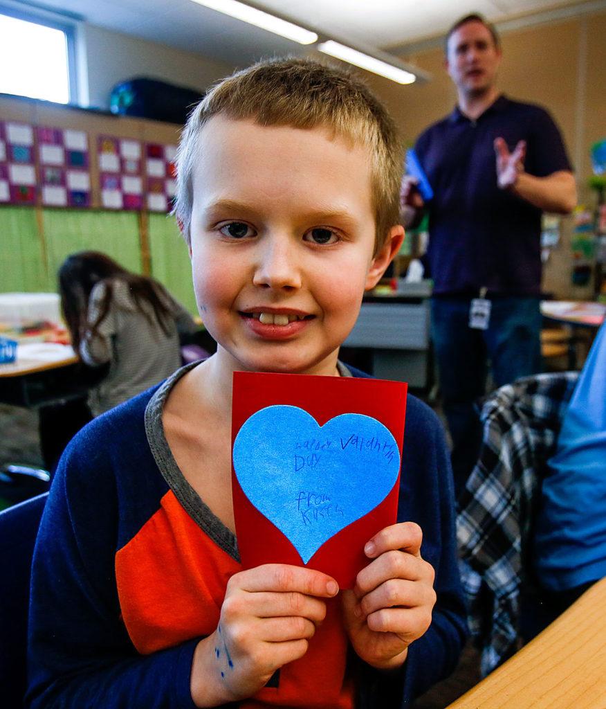 Fourth-grader Kasen Cooley shows off a Valentine’s Day card he made Thursday to donate to Valentines for Veterans. (Dan Bates / The Herald)
