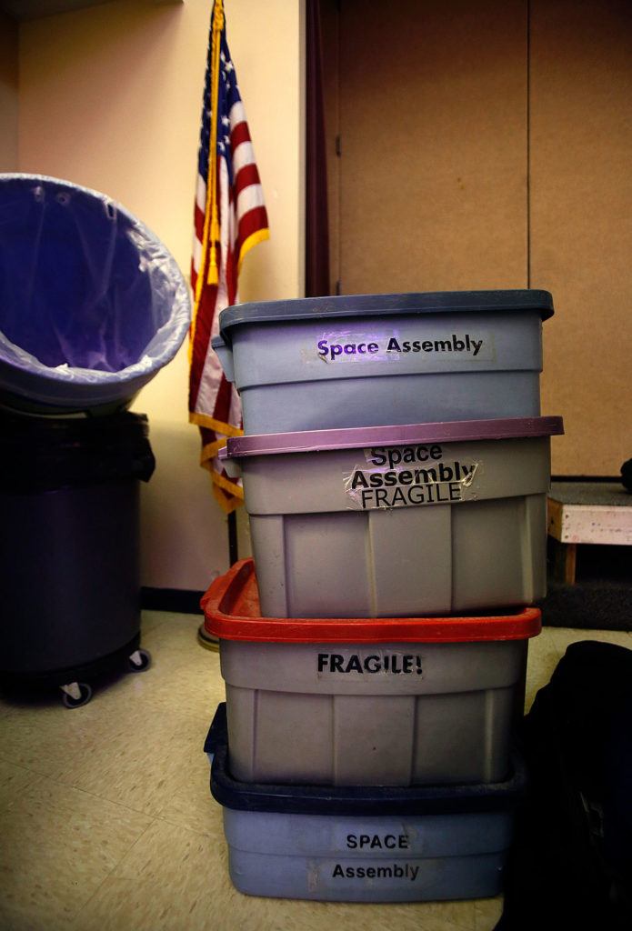 Containers of props, which could just as easily be marked “curiosity encouraged,” sit near the staging area where the Science on Wheels program is setting up a space show at Highland Elementary School in Lake Stevens on Thursday. (Dan Bates / The Herald)
