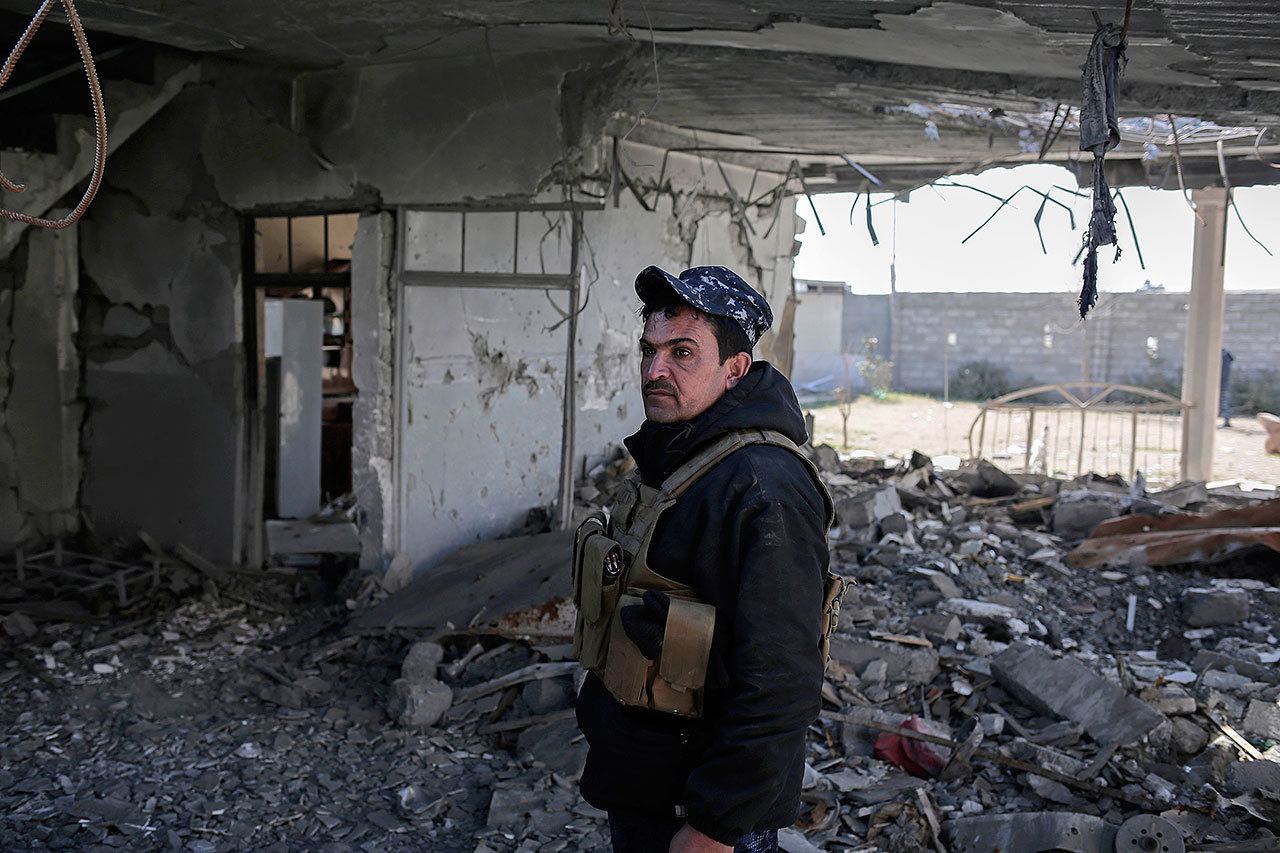A federal police officer stands inside a damaged house after it was hit by an air strike in Hamam al-Alil, Iraq, on Sunday. U.S.-backed Iraqi forces launched a large-scale military operation on Sunday to dislodge Islamic State militants from the western half of Mosul city. (AP Photo/Bram Janssen)