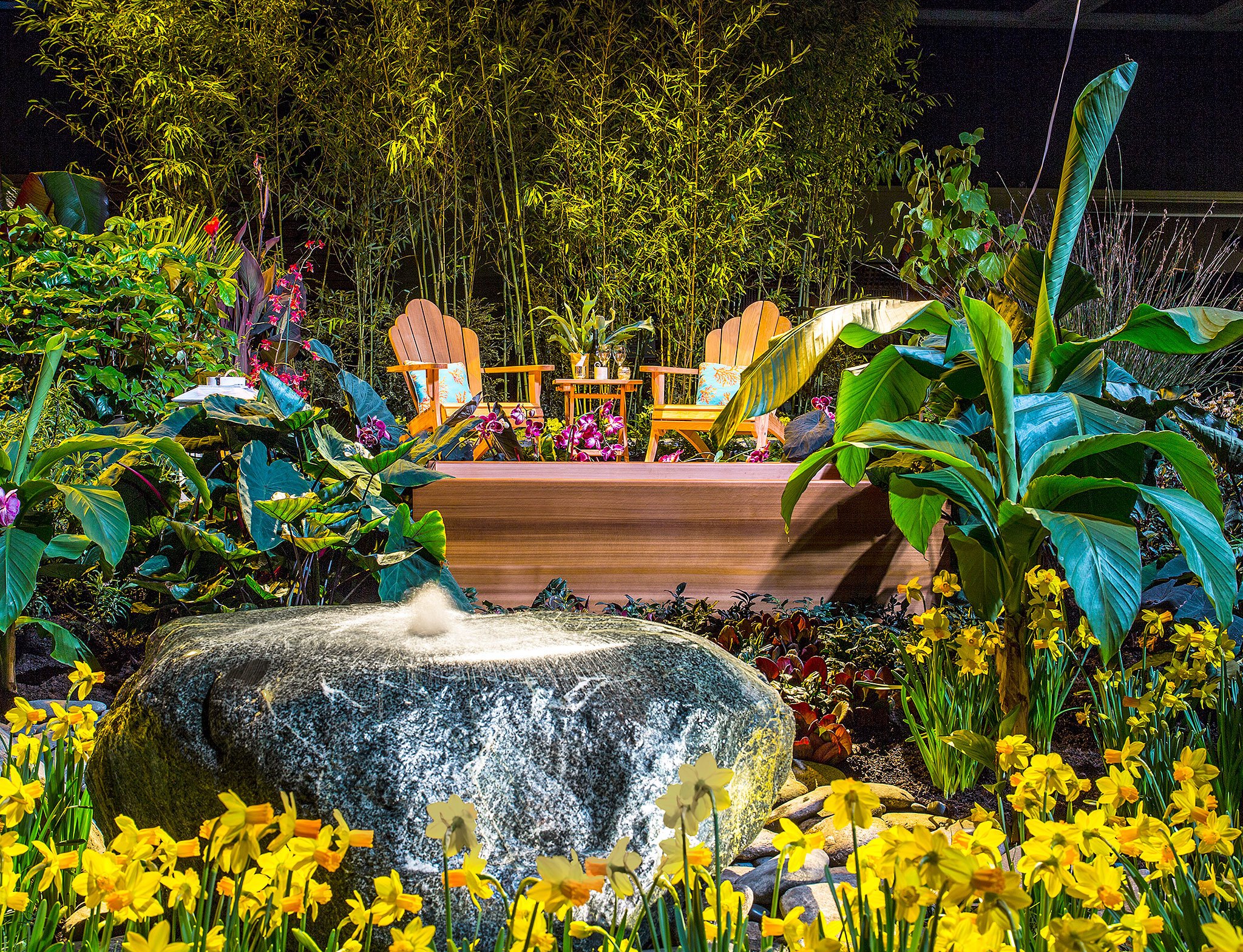 The 2016 display garden “A World Away on the Na Pali Coast” by Plantswoman Design, Bainbridge Island, showcases Hawaii’s wilderness and rainforest. The tropical setting has a deck constructed using sustainable cedar, Japanese soaking tub and fragrant foliage. A fountain created from native rock is both polished by man and rough-hewn by nature. The bamboo forest in the back of the garden reveals fresh viewpoints that encourage further exploration. (Northwest Flower & Garden Show)