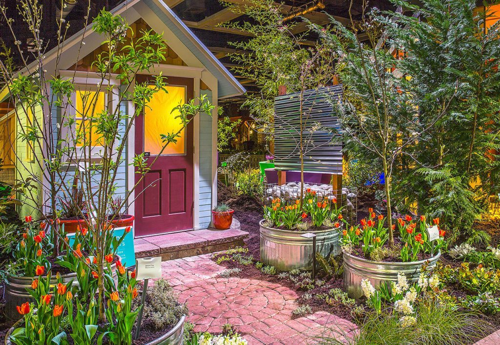 The 2016 display garden “Edible Neighborhood – A Food System on Every Block” by Cascadia Edible Landscapes of Seattle harkens back to the days when you shared seedlings and cuttings during “over the fence” conversations with neighbors, this garden spotlights how growing edible gardens provide a catalyst for community connectivity. (Northwest Flower & Garden Show)
