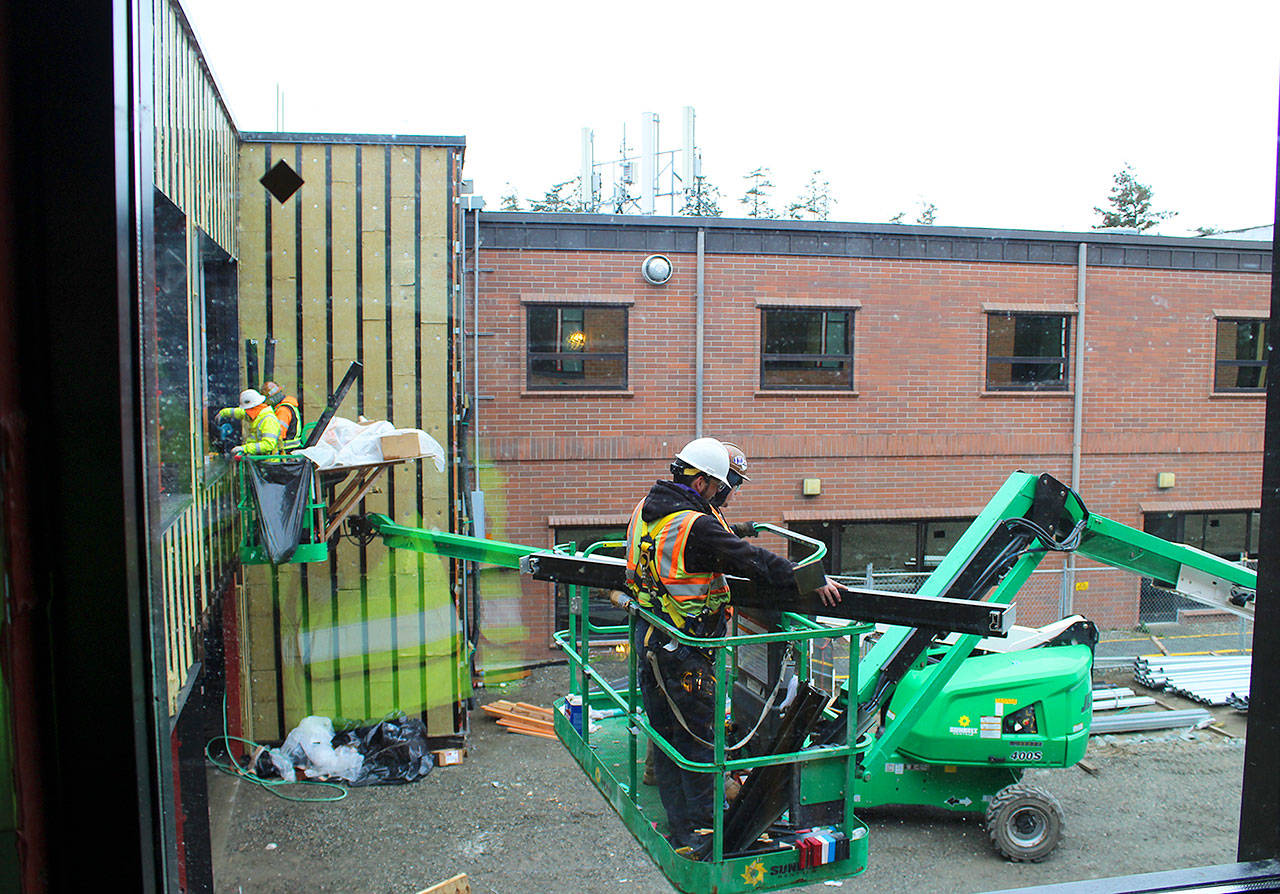 Construction workers at WhidbeyHealth Medical Center build the corridor that connects the old hospital to the $50 million addition. The 60,000-square-foot wing features 39 private patient rooms and many design elements for infection control and privacy. Photo by Patricia Guthrie/Whidbey News-Times