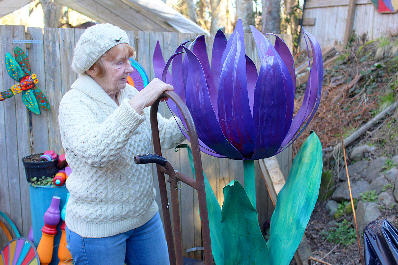 Vanca Lumsden with one of many pieces of colorful artwork used at the recent Northwest Flower & Garden Show. (Patricia Guthrie / Whidbey News-Times)