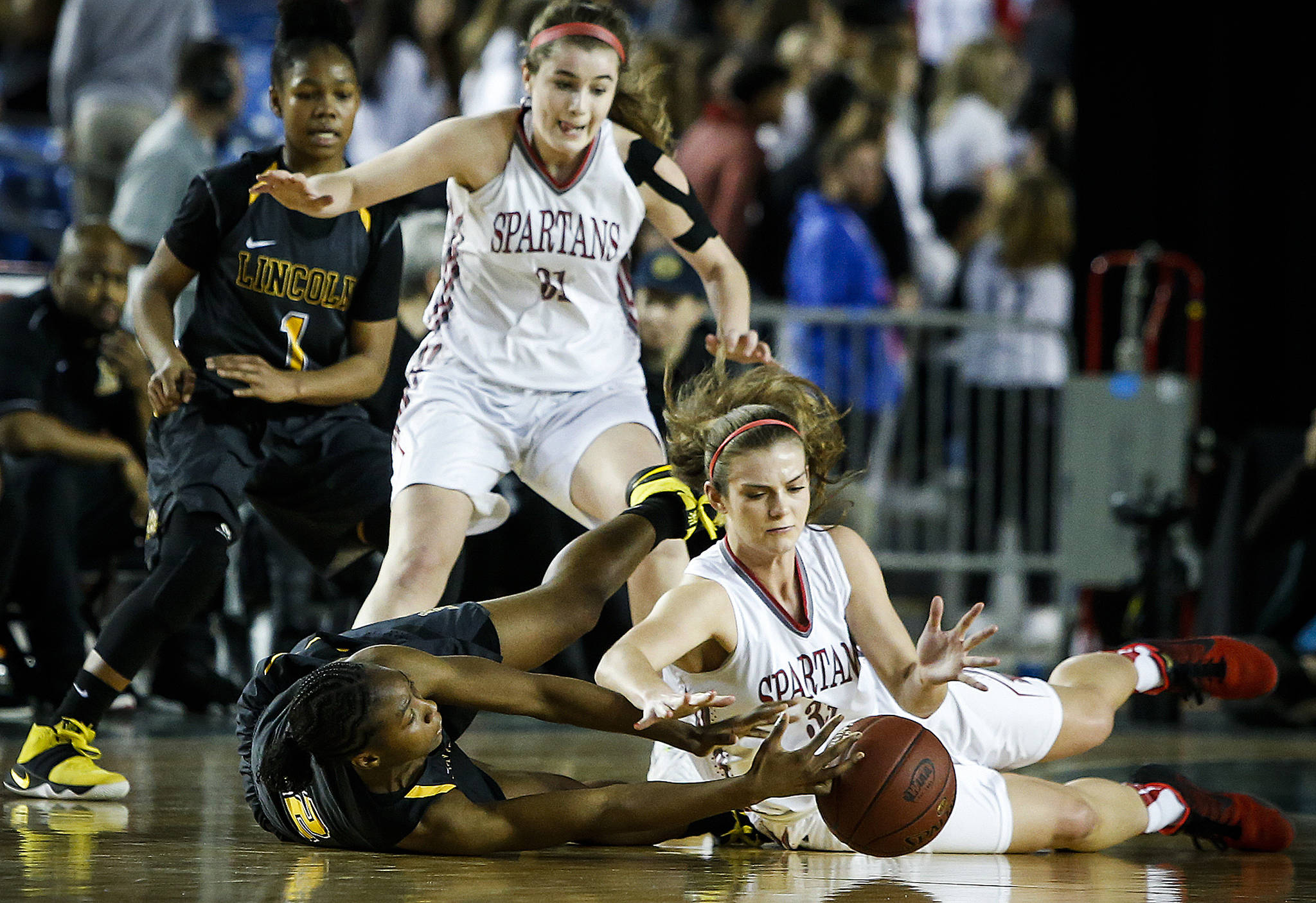 Stanwood’s Ashley Alter (right) and Lincoln’s Kondalia Montgomery (left) battle for a loose ball during a girls 3A state quarterfinal game at the Tacoma Dome on Thursday, March 2. Lincoln went on to defeat Stanwood 53-37. (Ian Terry / The Herald)