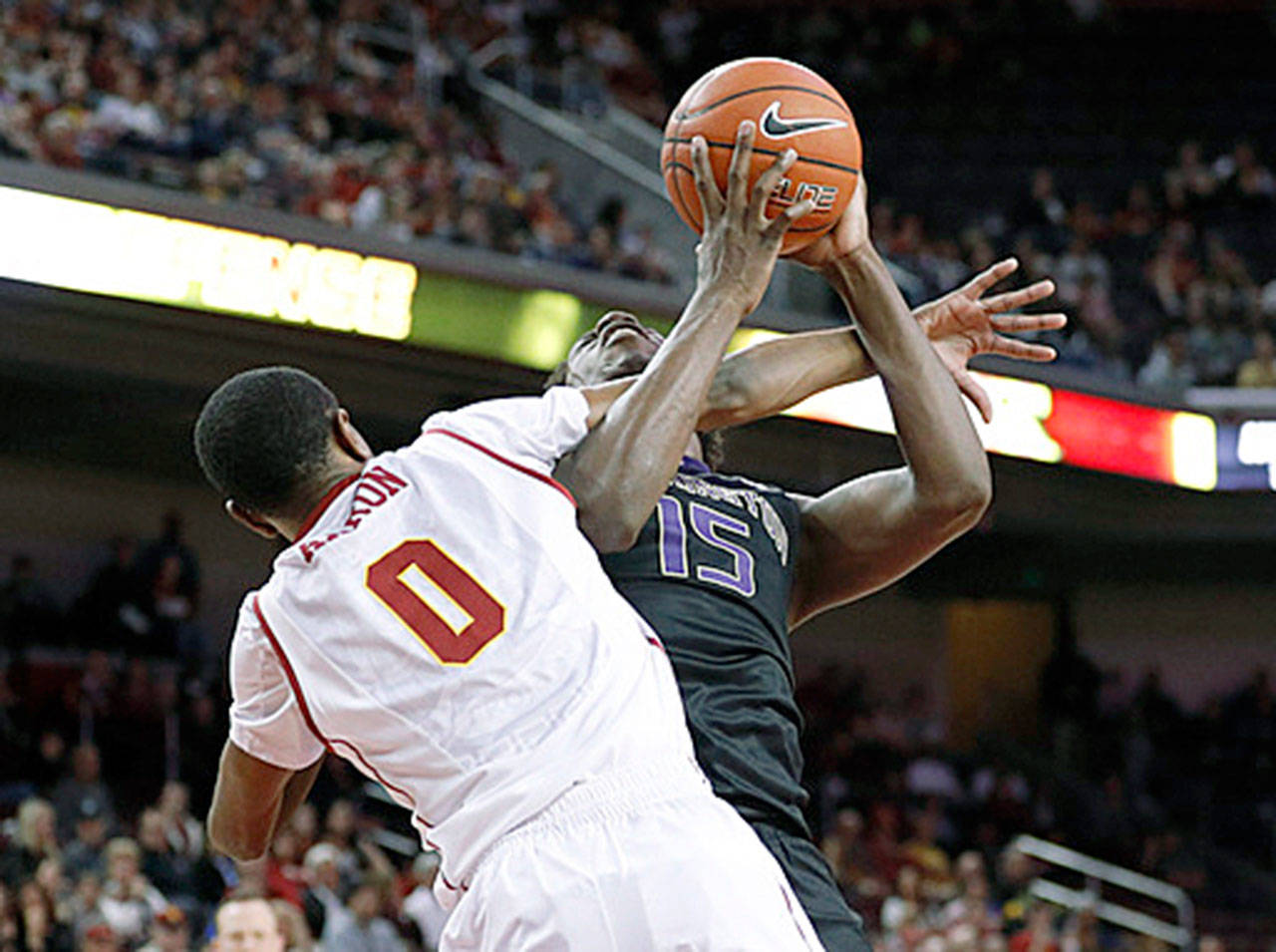 Washington’s Noah Dickerson (right) is fouled by Southern California’s Shaqquan Aaron during the Huskies’ loss to the Trojans on March 4 in Los Angeles. Dickerson will lead short-handed UW in another matchup against USC in its Pac-12 tournament opener on Wednesday in Las Vegas. (AP Photo/Jae C. Hong)