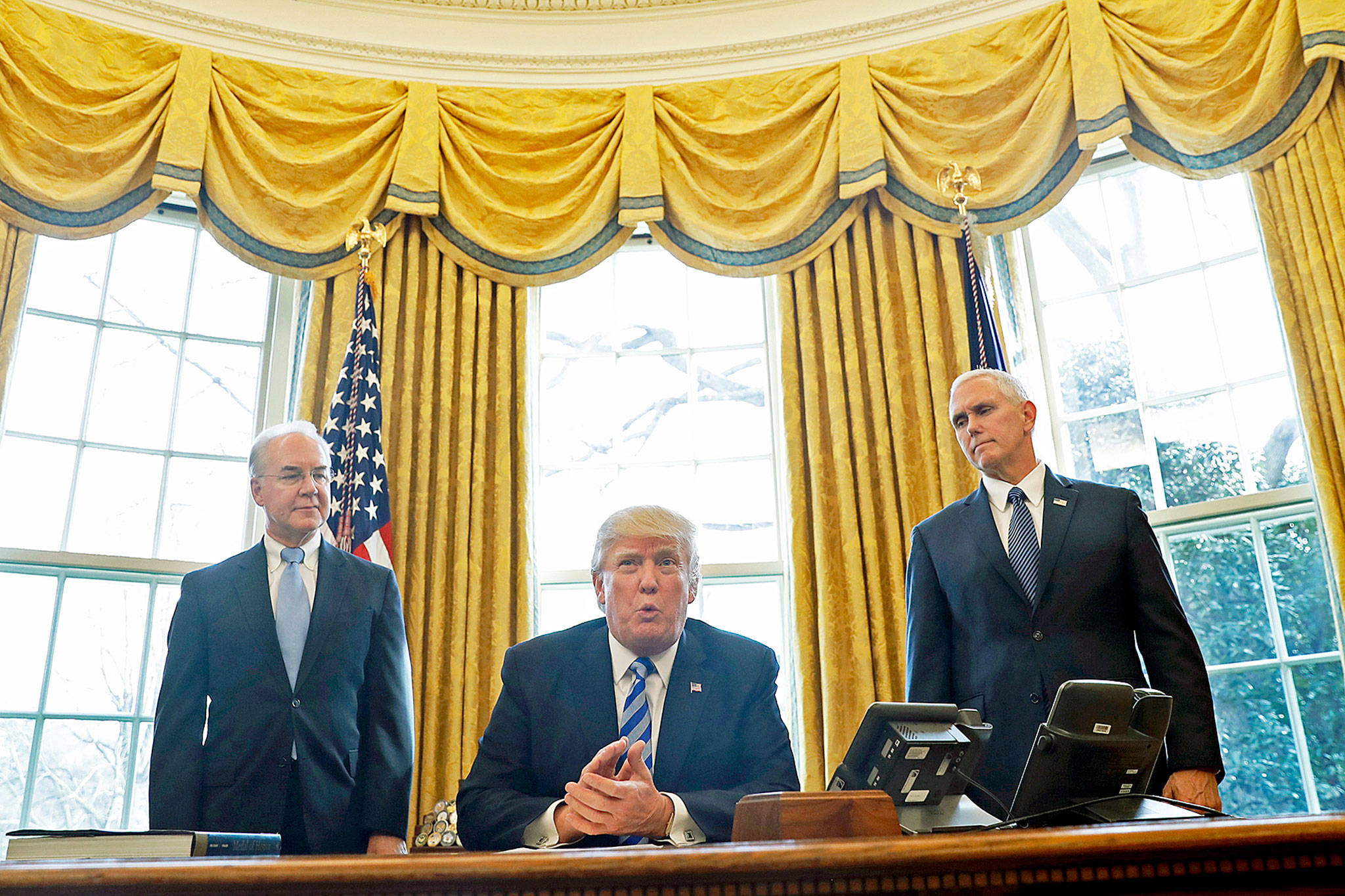 President Donald Trump, flanked by Health and Human Services Secretary Tom Price (left) and Vice President Mike Pence, meets with members of the media regarding the health care overhaul bill on Friday in the Oval Office of the White House in Washington. (AP Photo/Pablo Martinez Monsivais)