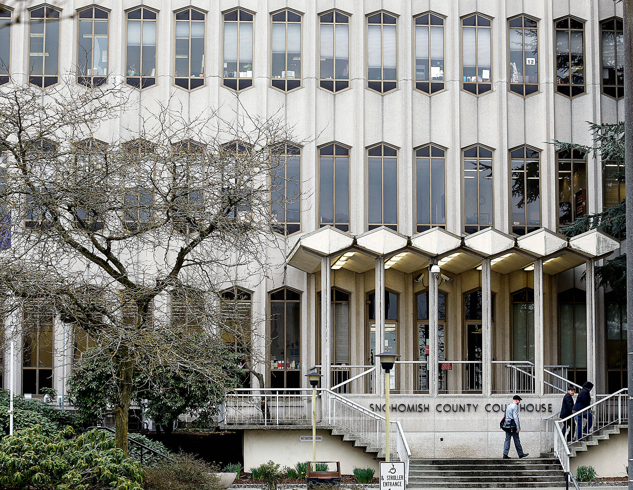 A handful of people come and go at the main entrance to the Snohomish County Courthouse late Monday afternoon. (Dan Bates / The Herald)