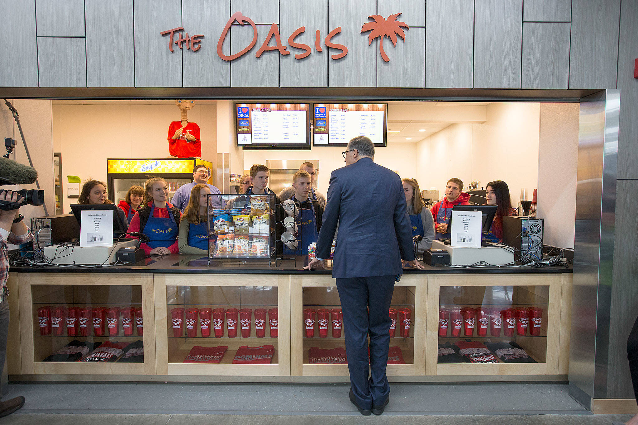 Gov. Jay Inslee talks with DECA Club students at the Oasis Cafe, the student store, Tuesday in Marysville Pilchuck High School’s new cafeteria. (Andy Bronson / The Herald)
