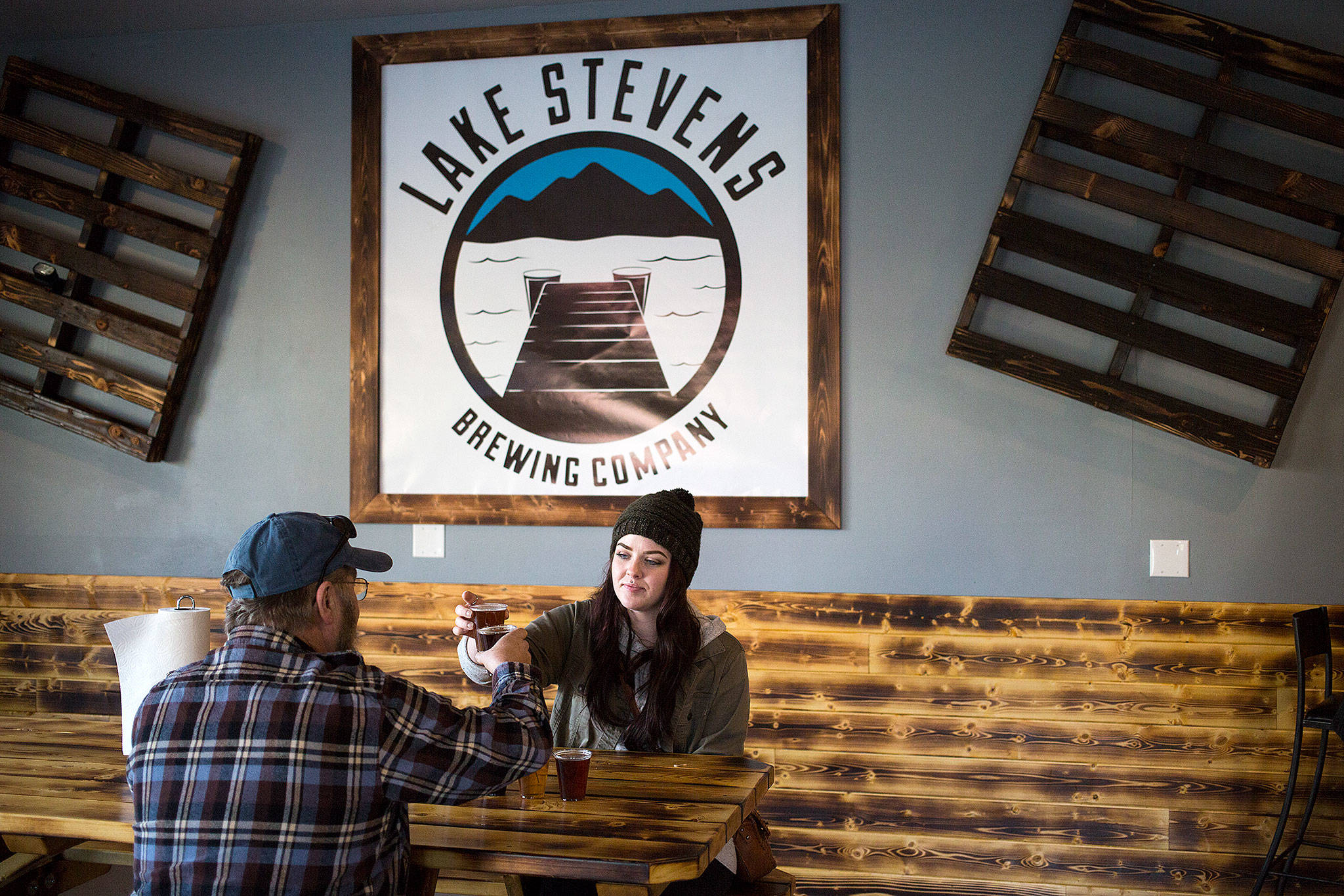 Julia Turner and her father, Ed, toast as they sample the beer and cider at Lake Stevens Brewing Co., the first brewery in the city. (Andy Bronson / The Herald)