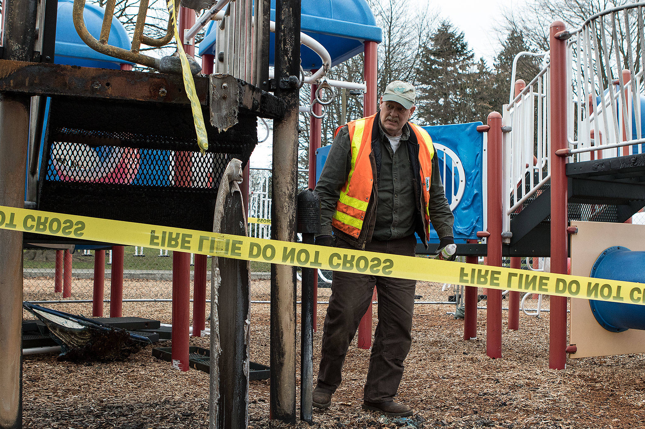 City of Everett Parks and Recreation maintenance mechanic Colin Moriarty cleans up a playground Wednesday at Everett’sAmerican Legion Memorial Park after it was destroyed last month in a fire. (Andy Bronson / The Herald)