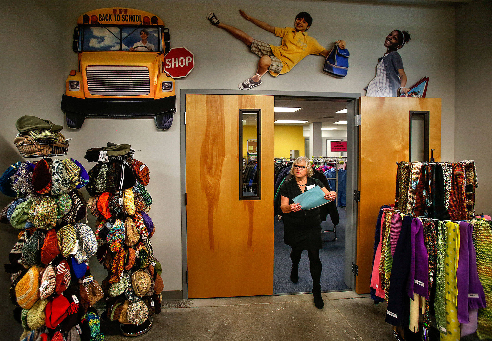 Providing more than the expected: Diane Pedack works with the children’s clothes inventory at Operation School Bell, which includes a selection of fine hand-knitted hats and scarves. (Dan Bates / The Herald)