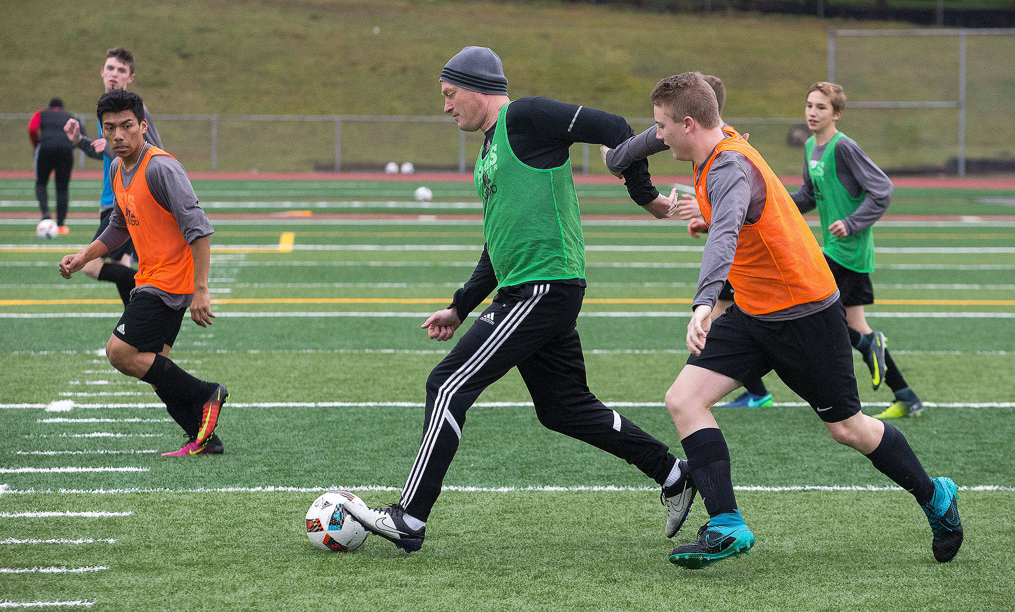 Snohomish boys soccer coach Matt Raney (center) participates in a drill with the team during practice on Monday. Raney takes over this season for Dan Pingrey, who coached the varsity team for 18 years. (Andy Bronson / The Herald)