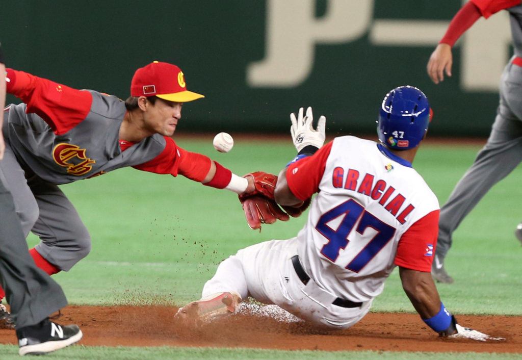 Cuba’s Yurisbel Gracial steals second base as the ball gets away from China second baseman Du Xiaolei during the second inning of their first-round game Wednesday at the World Baseball Classic in Tokyo. (AP Photo/Koji Sasahara)
