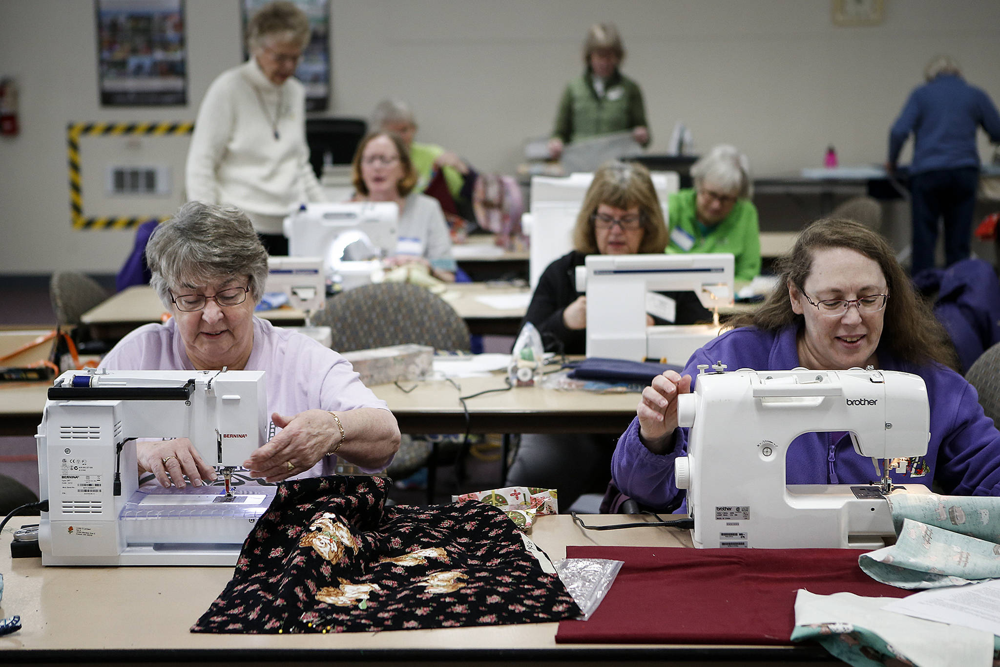 Linda Lambert (left), of Everett, and Vickie Sawade, of Snohomish, sew tote bags with other members of the Snohomish County Sewing and Textile Advisors at McCollum Park in Everett on March 17. The completed bags all went to Safe Place, an Everett shelter for homeless children. (Ian Terry / The Herald)