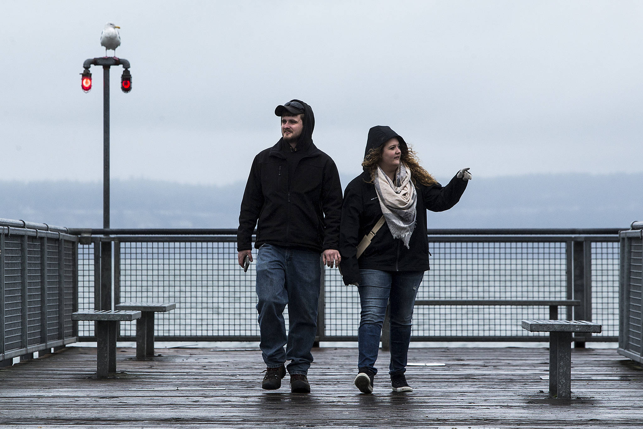 Kaitlin Vos and Zach Jacoby walk along the pier at Kayak Point Park in Stanwood on Tuesday. The pair, who are from Marshall, Minnesota, are in Stanwood visiting Vos’ family. (Ian Terry / The Herald)
