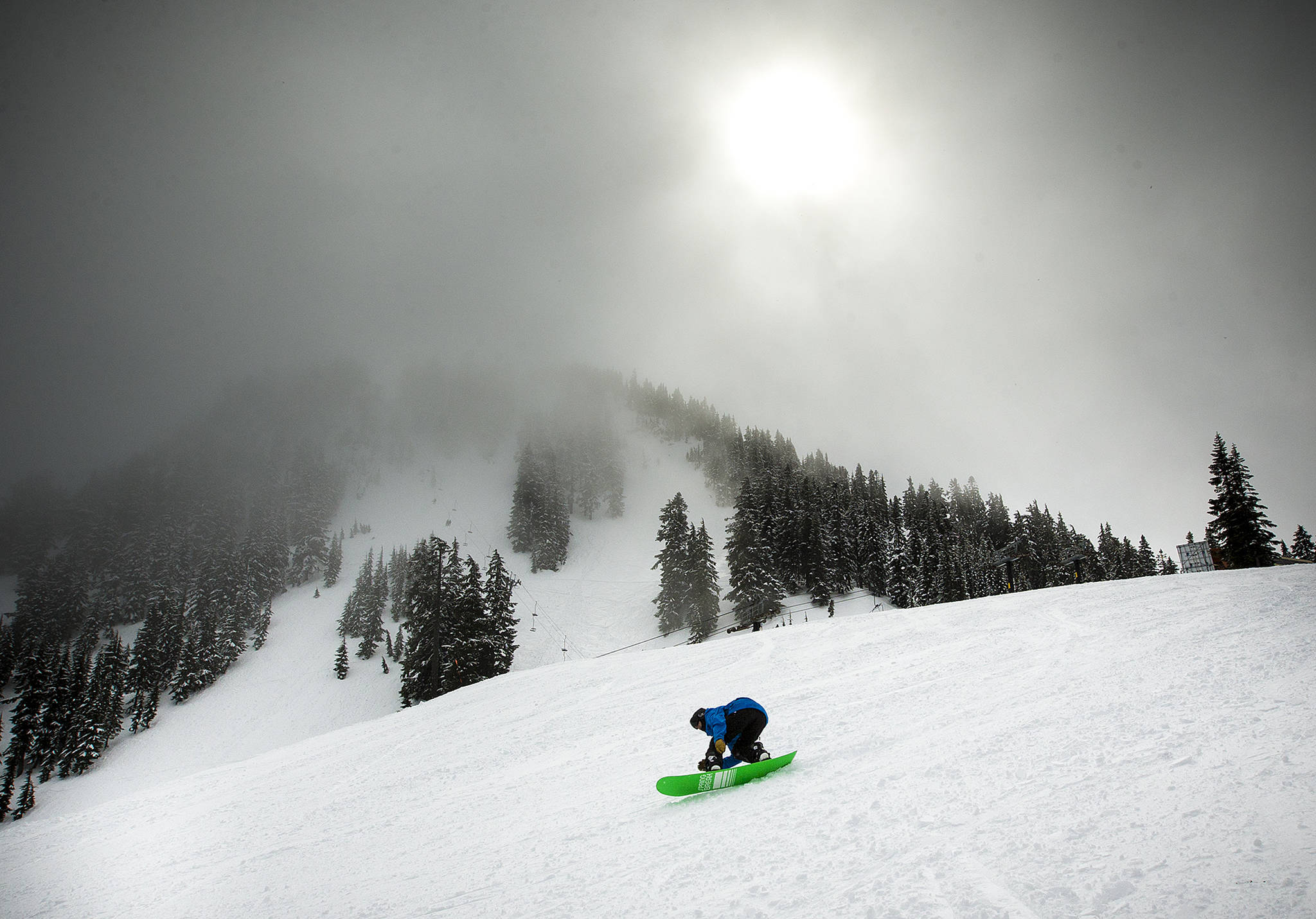 Dark clouds hang above Barrier Ridge near the top of the Skyline chairlift at Stevens Pass on Wednesday, March 22. With cold temperatures and plenty of precipitation providing a solid base of snow, Stevens Pass is on pace to break its record for most visitors in one season. (Ian Terry / The Herald)