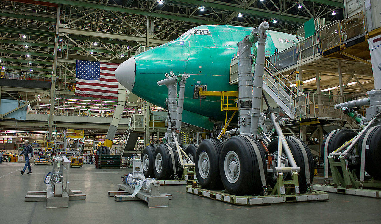 A worker walks near a 747-8 airplane at the Boeing Co. factory in Everett. (David Ryder / Bloomberg News, 2015)