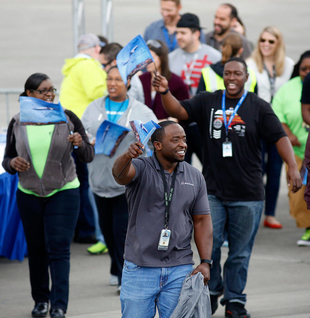 Boeing employees carry 787-10 Dreamliner flags during the first flight ceremony Friday. (AP Photo/Mic Smith)
