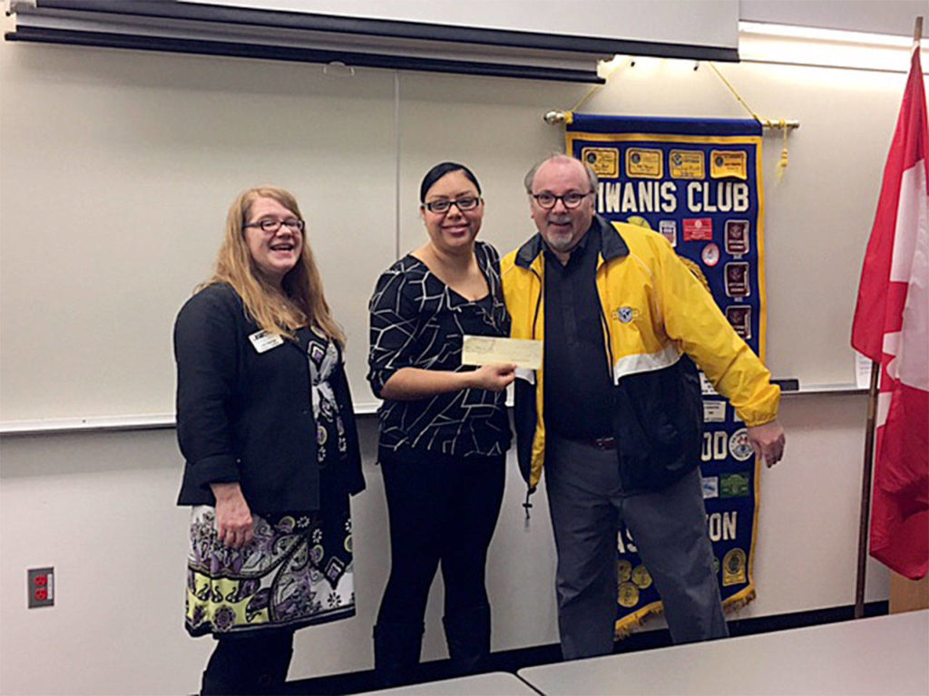 Clothes For Kids representatives Lisa George and Yuliana Flores-Montes receive a $2,000 check from Lynnwood Kiwanis President Ron Swengel at the March 2 Kiwanis meeting. (Contributed photo)
