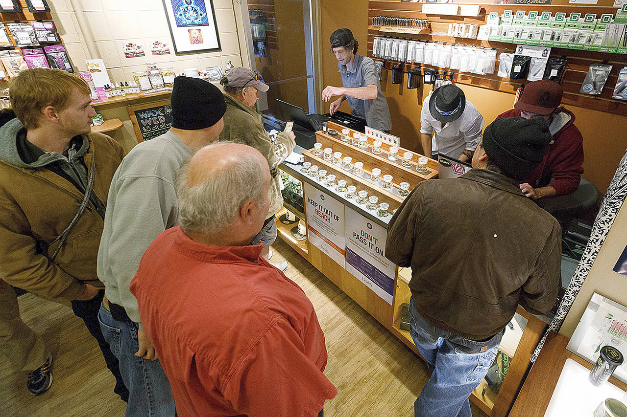 In this 2015 photo, employees of Amazon Organics, a pot dispensary in Eugene, Oregon, help customers purchase recreational marijuana. (AP Photo/Ryan Kang, File)