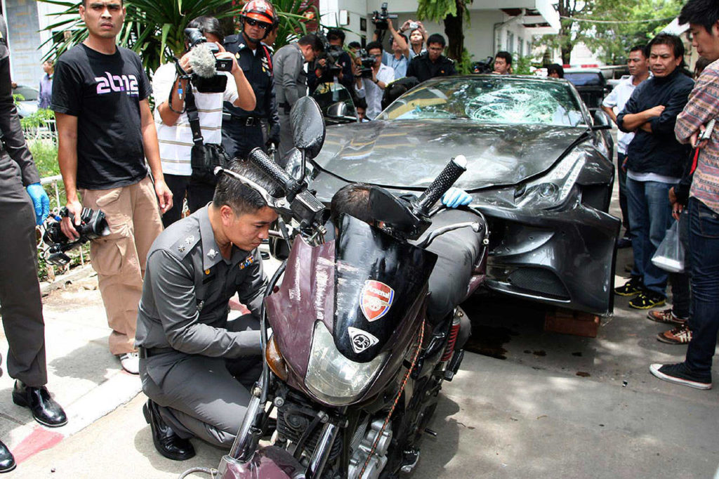 In this Sept. 3, 2012, photo, a Ferrari that was driven by Vorayuth Yoovidhya, a grandson of late Red Bull founder Chaleo Yoovidhya, and a motorcycle, both involved in an accident, are displayed by police in Bangkok. (Thai Daily News via AP)
