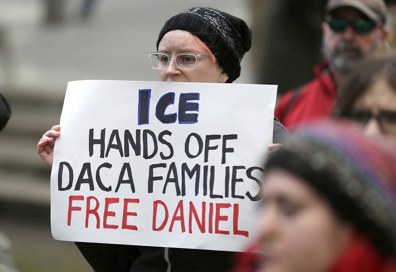 In this Feb. 17 photo, a protester holds a sign that reads “ICE Hands Off DACA Families Free Daniel,” during a demonstration in front of the federal courthouse in Seattle. (AP Photo/Ted S. Warren, file)