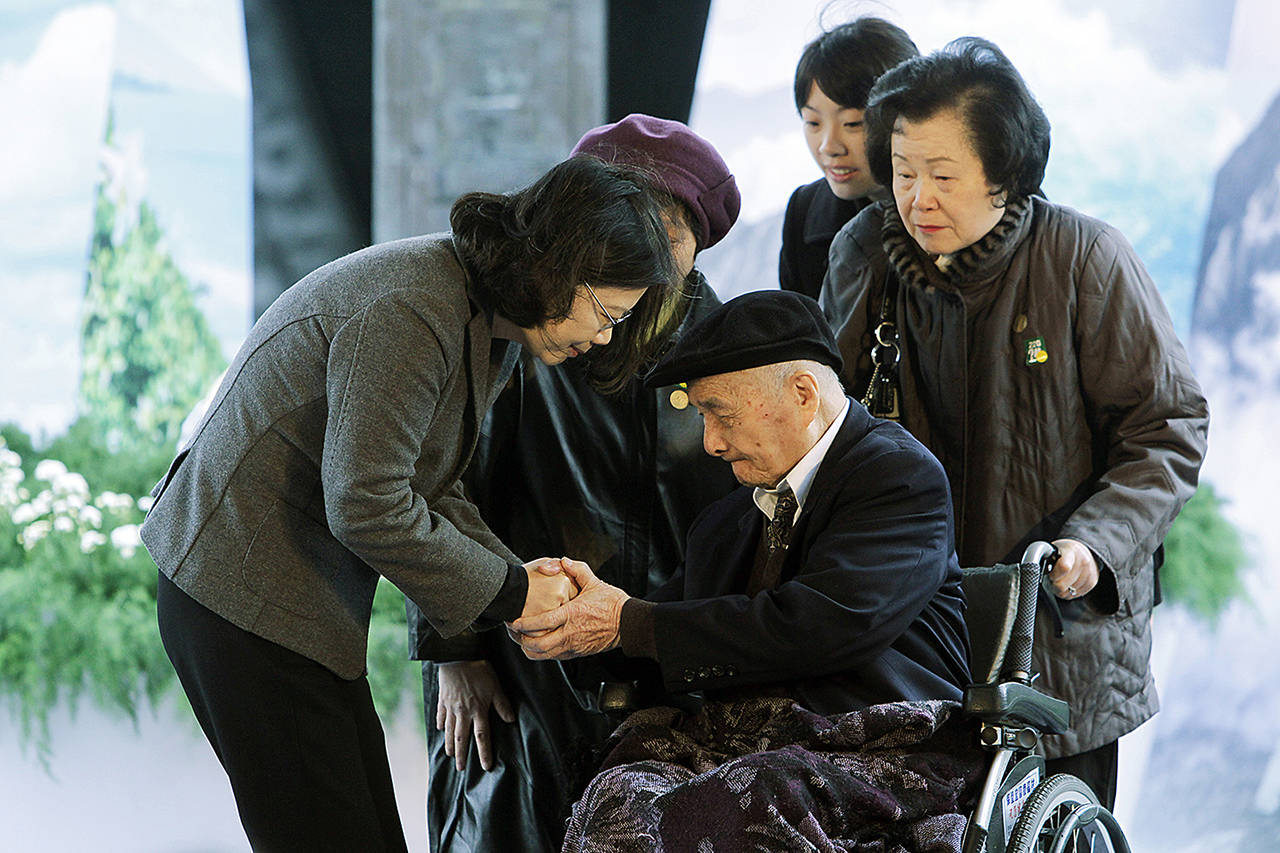 Taiwanese President Tsai Ing-wen (left) gives her regards to 96-years-old victim Fu Jen-hung during a memorial service marking the 228 Incident in Taipei, Taiwan, on Tuesday, Feb. 28. (AP Photo/Chiang Ying-ying)