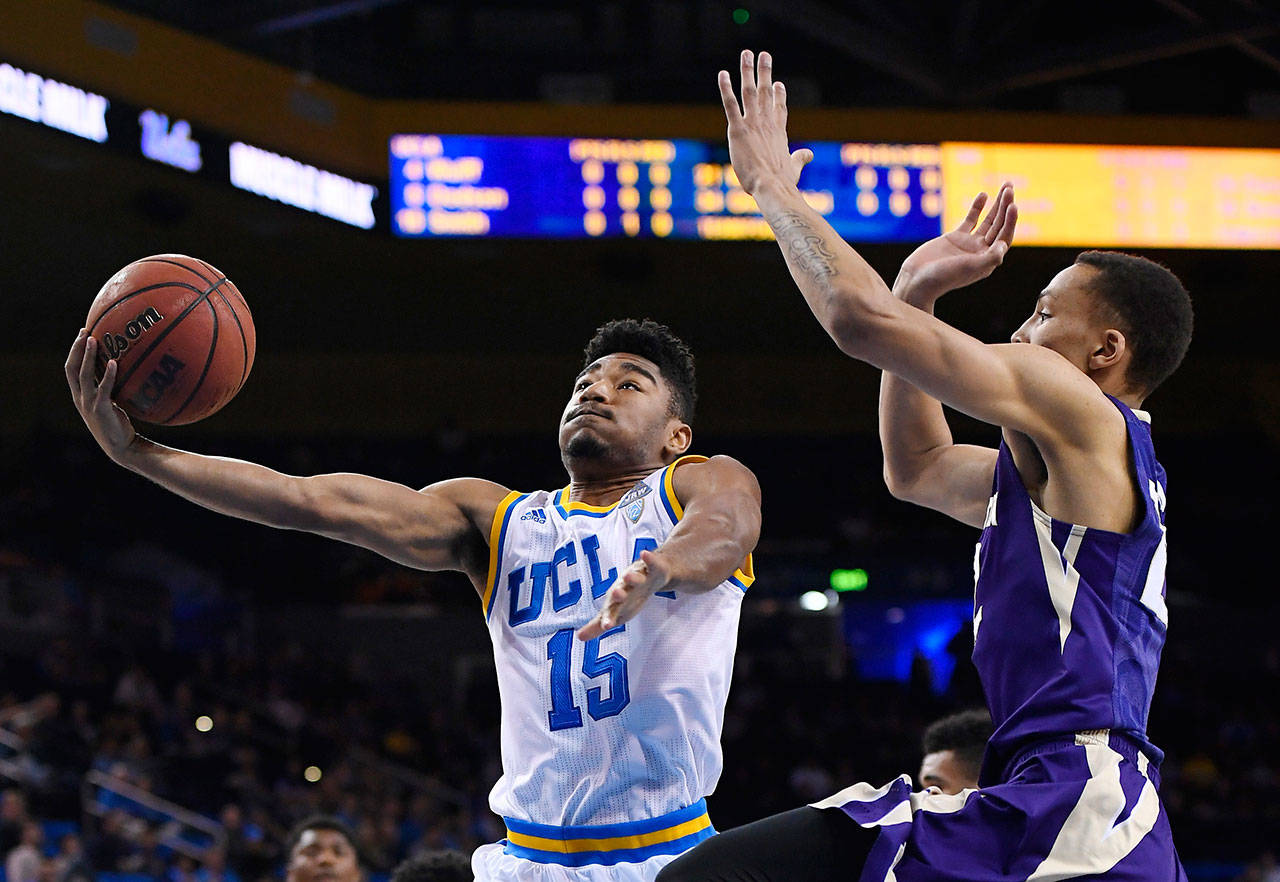 UCLA guard Jerrold Smith (left) shoots as Washington forward Dominic Green defends during the second half of a game March 1, 2017, in Los Angeles. UCLA won 98-66. (AP Photo/Mark J. Terrill)