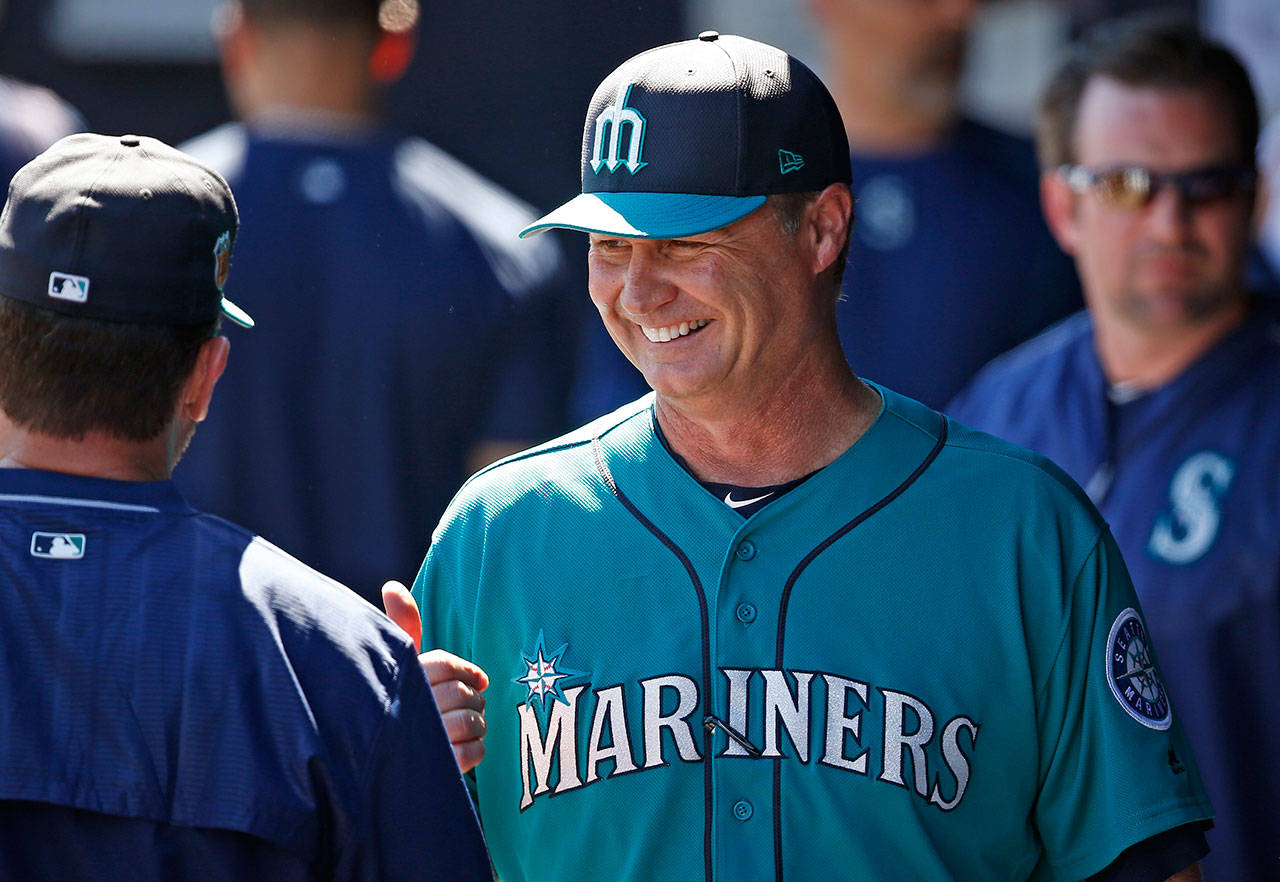 Mariners manager Scott Servais smiles as he talks to a coach prior to a spring training game against the Cubs on March 10, 2017, in Peoria, Ariz. (AP Photo/Ross D. Franklin)